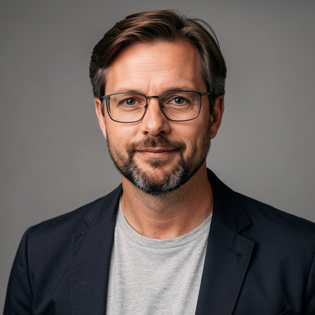 Studio portrait of a Danish man with a beard and glasses